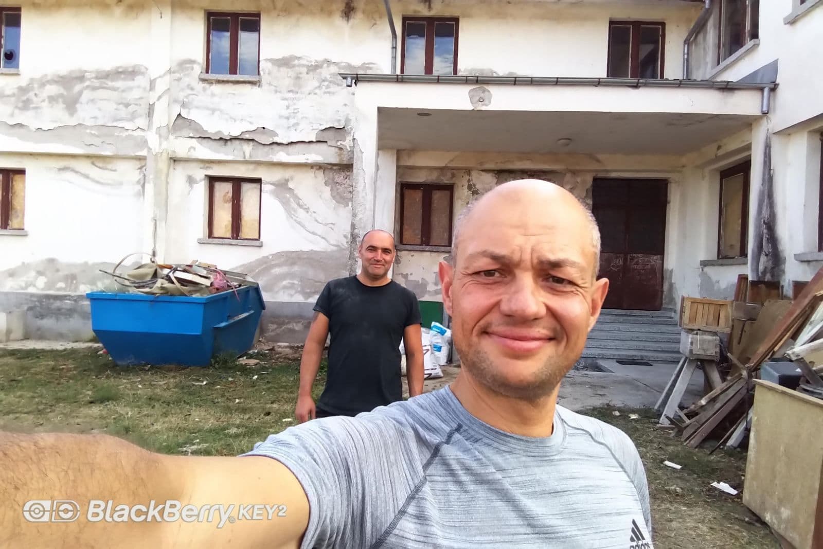 Двама от екипа пред сградата по време на ремонта